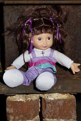 Here is a close-up of a doll sitting on a brick ledge.  The doll doesn't look that old, but for some reason it looked pretty creepy sitting there like that.